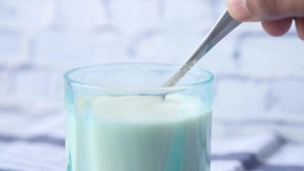 Milch mit Löffel in Nahaufnahme rühren — Stockvideo
