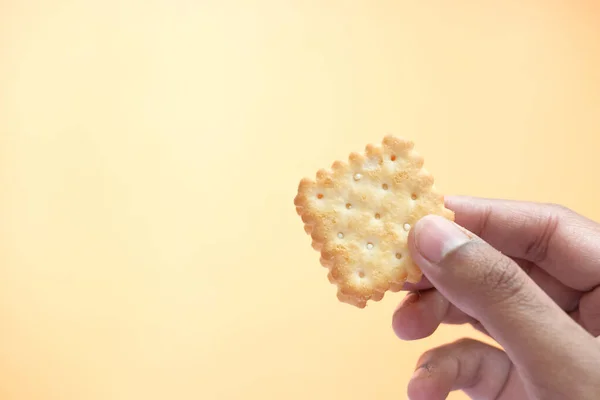 Mão segurando biscoitos doces no fundo da cor — Fotografia de Stock