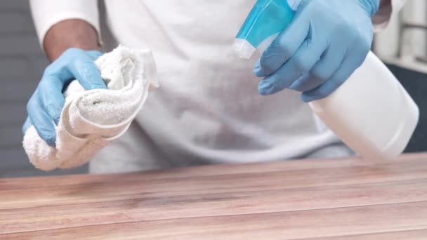 테이블 표면을 청소하기 위해 살균제 스프레이를 사용하여 일회용 장갑을 사용하는 모습 — 비디오