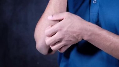 Kaşınan deriden muzdarip bir adam, siyah üzerine izole edilmiş. 