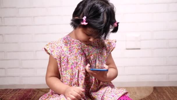 Дитяча дівчина дивиться мультфільм на смартфон — стокове відео