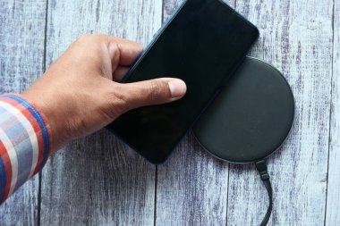Kablosuz şarj pedi kullanarak akıllı telefon şarj ediliyor, üst görünüm 