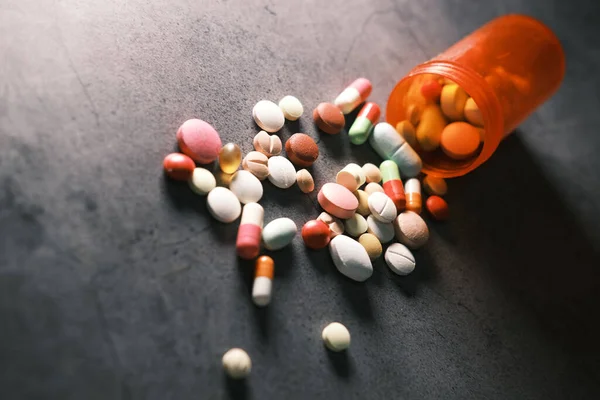 Närbild av många färgglada piller och kapslar på svart bakgrund — Stockfoto