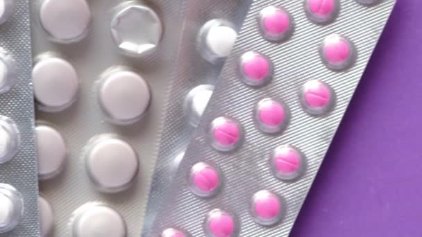Zbliżenie tabletek z blistrami na fioletowym tle — Wideo stockowe