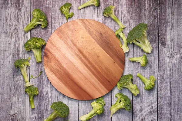 Fatia de brócolis e tábua de corte na mesa — Fotografia de Stock