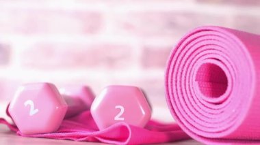  Pembe halterler, spor paspası ve beyaz arka planda su şişesi. 