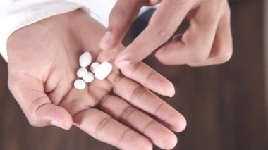 Beyaz hapların ya da avucundaki ilaçların üst görünümü 