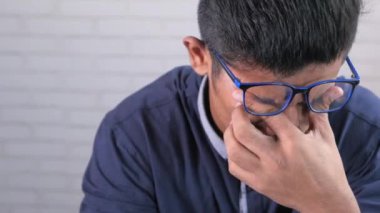 Güçlü göz ağrısından muzdarip üzgün adama yaklaş.