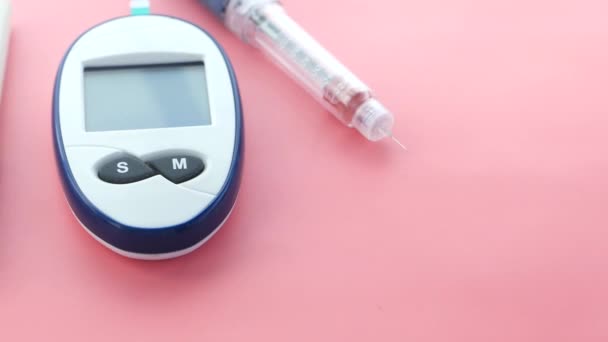 Close-up van diabetische meetinstrumenten, insuline en pillen op kleurachtergrond — Stockvideo