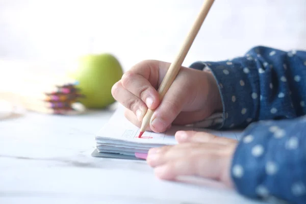 Close-up van een kind hand tekening met kleurpotlood op een pagina. — Stockfoto