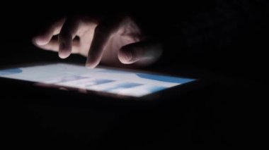 Adam el ile ofis masasında dijital tablet üzerinde çalışıyor, kendi yarattığı grafiği kullanarak. 