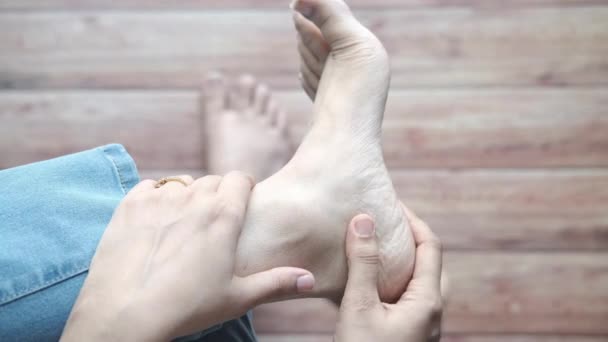 여자의 발과 손을 상처 부위에 대고 마사지를 한다. — 비디오