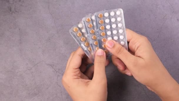 Women hand holding birth control pills on black background — Stock Video