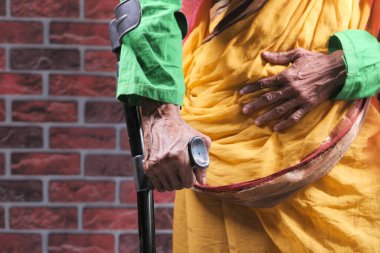 Koltuk değneklerinde kırık bacağı olan yaşlı kadınlar..