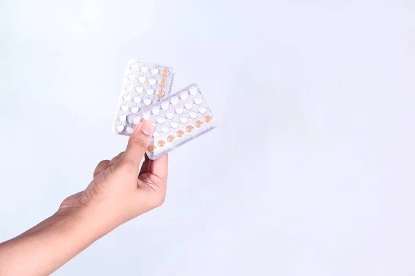 Vrouwen hand golding anticonceptiepillen geïsoleerd op wit — Stockfoto