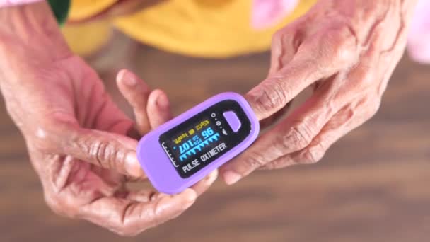 Bovenaanzicht van senior vrouwen hand met behulp van pulse oximeter — Stockvideo