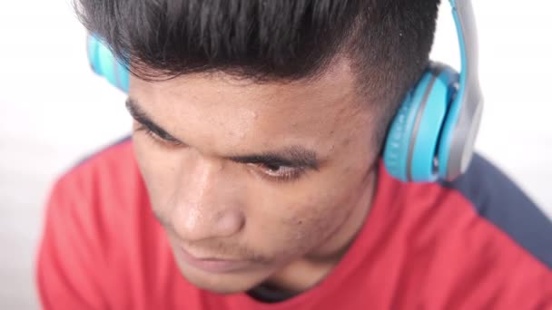 Pemuda menempatkan headphone biru dekat — Stok Video