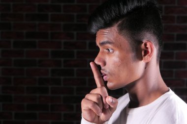 Siyah bir aynaya bakan genç adamın yan görüntüsü. 