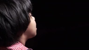 Siyah üzerinde uzun saçlı, neşeli bir kızın yan görünüşü. 