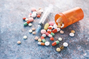 Karanlık arka planda şırınga ve haplar, kapatın. 