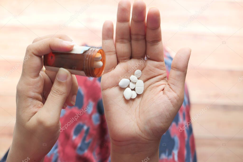Close up of women hand taking pills 