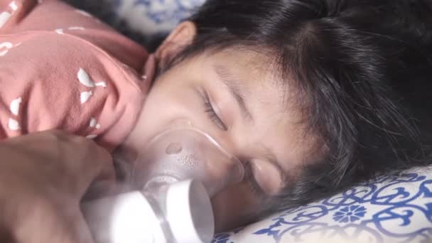 Ein Kind schläft auf dem Bett, während es Vernebler nimmt — Stockvideo