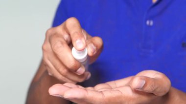 Delikanlının elini dezenfektan spreyiyle kapat..