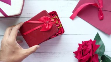  kalp şeklinde hediye kutusu ve ahşap arka planda gül çiçeği 