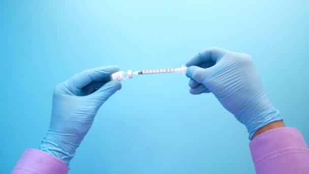 Hand in blue latex gloves fill in syringe with medicine isolated on white — Stock Video