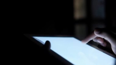 Geceleri dijital tablet üzerinde çalışan bir kişinin el dikiz görüntüsü 
