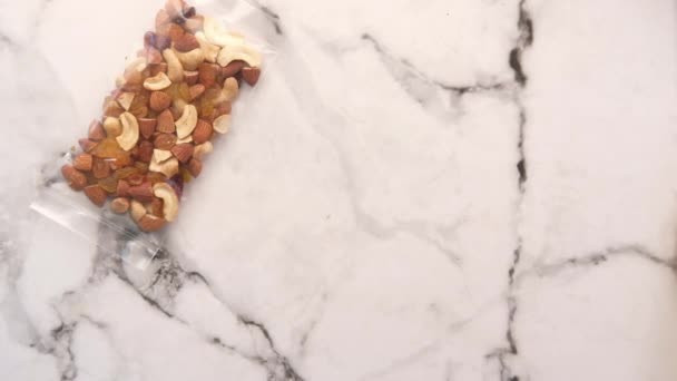 Покласти пакет змішаних горіхів на стіл — стокове відео