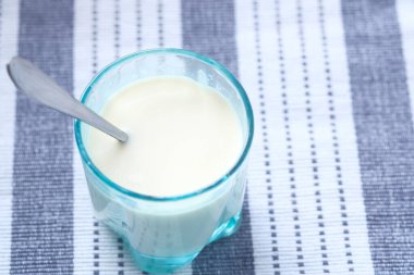 Masadaki bir bardak süt ve kaşığı kapat. 