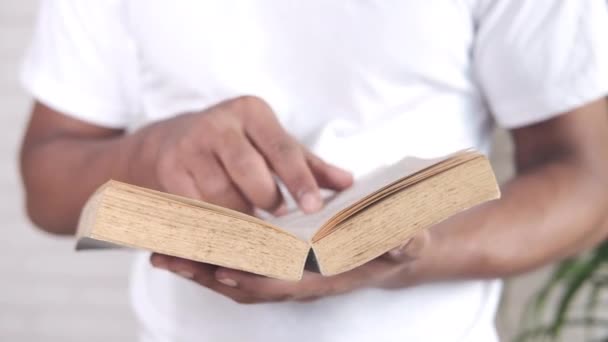 Крупним планом молодий чоловік читає книгу — стокове відео