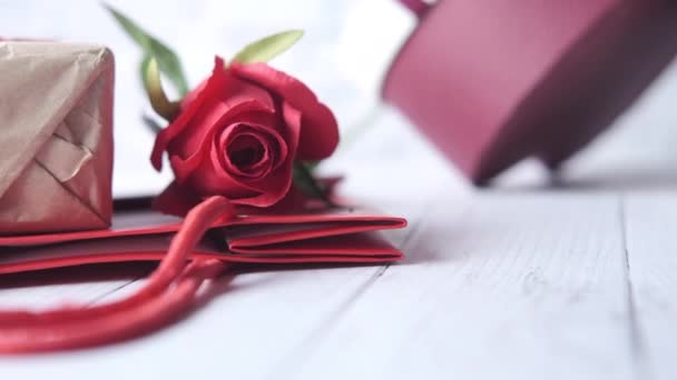 Primer plano de flor de rosa y caja de regalo en la mesa — Vídeos de Stock