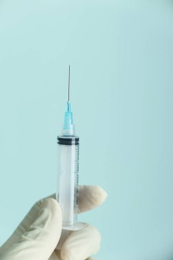 Doktor elinde şırınga tutan tıbbi eldivenler getirdi..