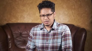  Asyalı genç adam öksürüyor ve koltukta hapşırıyor. 