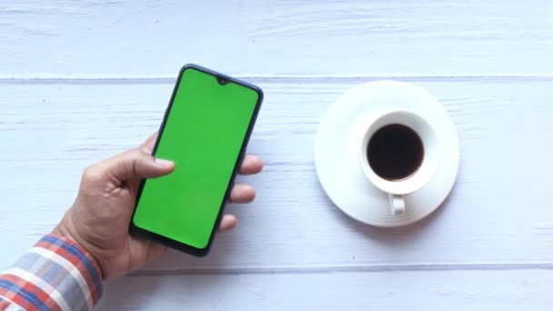 Bovenaanzicht van de man hand houden smartphone en het drinken van thee — Stockvideo