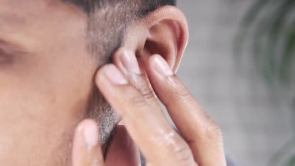 Zblízka mladý muž drží ucho trpí bolestí — Stock video