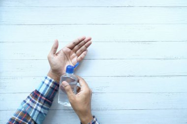 Masadaki korona virüsünü önlemek için dezenfektan sıvısı kullanılıyor. 