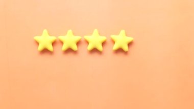 Müşteri değerlendirme konsepti. Turuncu arkaplanda altın yıldızları sıralamak 