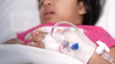 Bebek eli bandajlı Yatakta serum fizyolojik veriyor