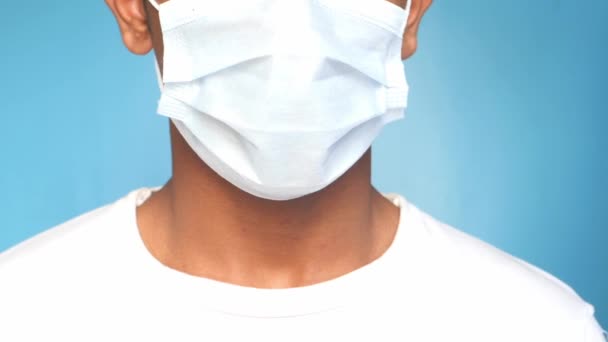 Jeune asiatique homme putting chirurgical visage masque intérieur — Video