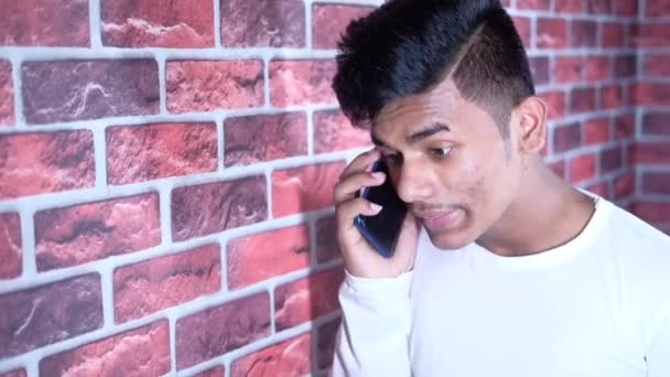 Сердитий молодий чоловік говорить на смартфоні — стокове відео