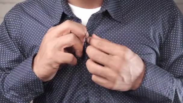 Mannen knäpper sin skjorta på nära håll — Stockvideo