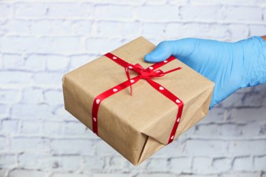 Mavi eldivenli erkek eli bir hediye veriyor..