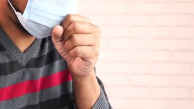  Genç Asyalı adam öksürüyor ve hapşırıyor. 