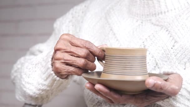 Senioren hand met een kopje groene thee — Stockvideo