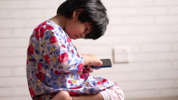 한 어린이가 스마트폰으로 만화를 보고 있다 — 비디오