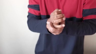 Delikanlı dezenfektan sıvısıyla elini temizliyor. 