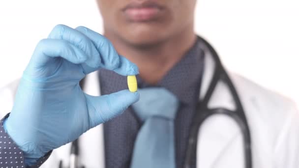 Medico mano in guanti protettivi con pillole bianche o medicina — Video Stock